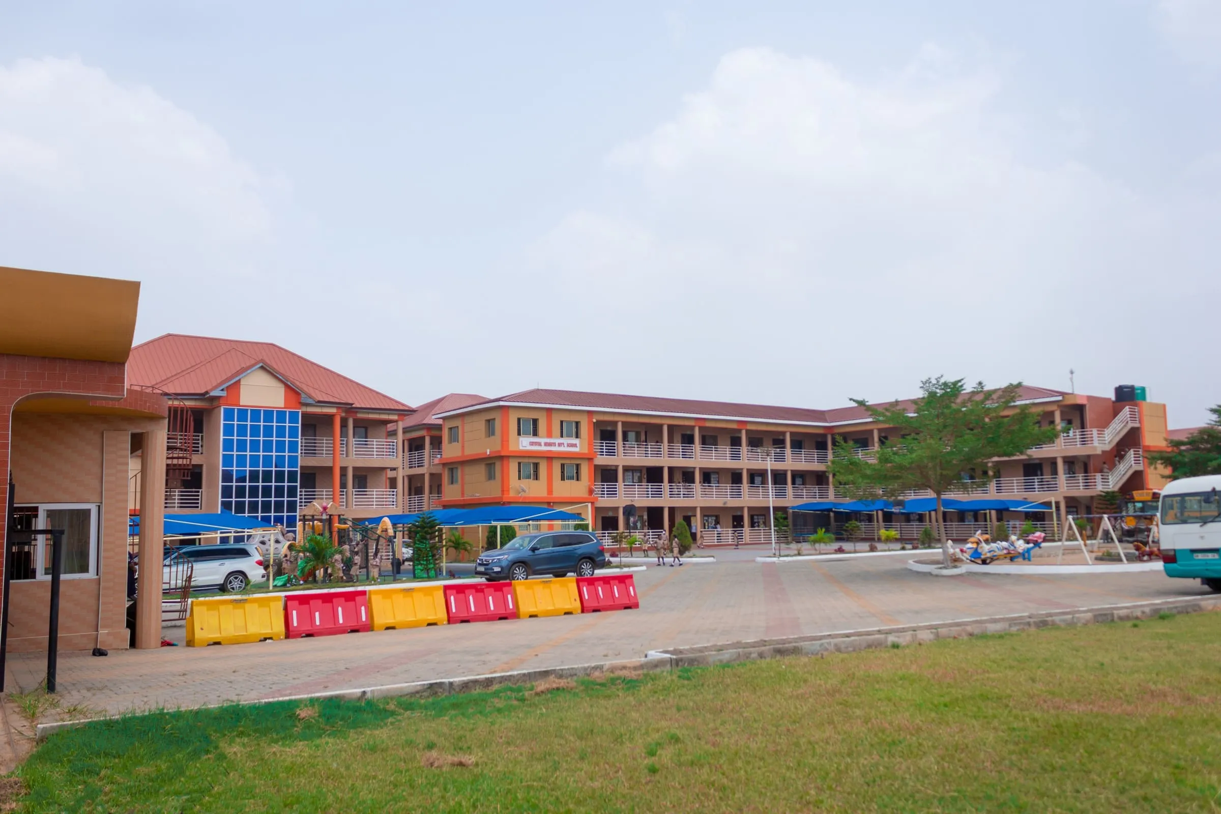 The Crystal Heights campus forecourt in the morning, amber buildings around the courtyard
