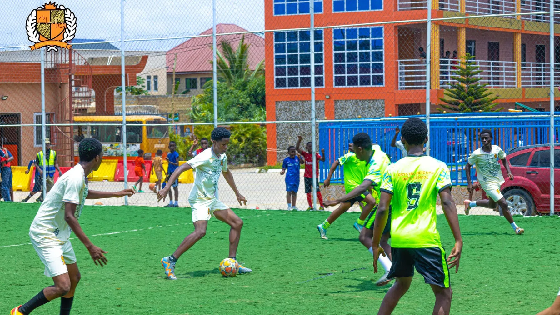 A football match on the Crystal Heights astroturf pitch, the school buildings behind