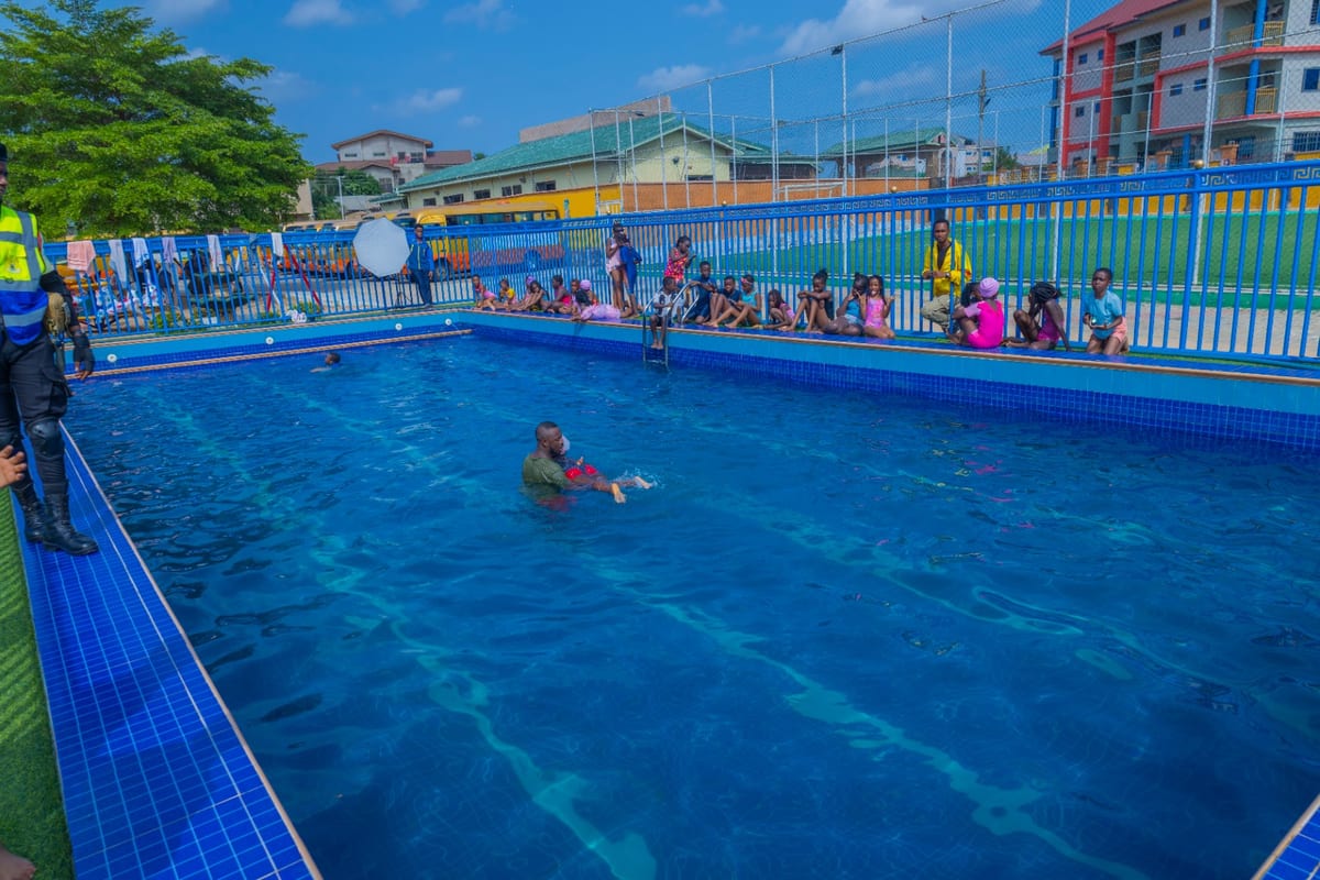 A swimming lesson in progress in the pool at Crystal Heights, pupils waiting at the poolside